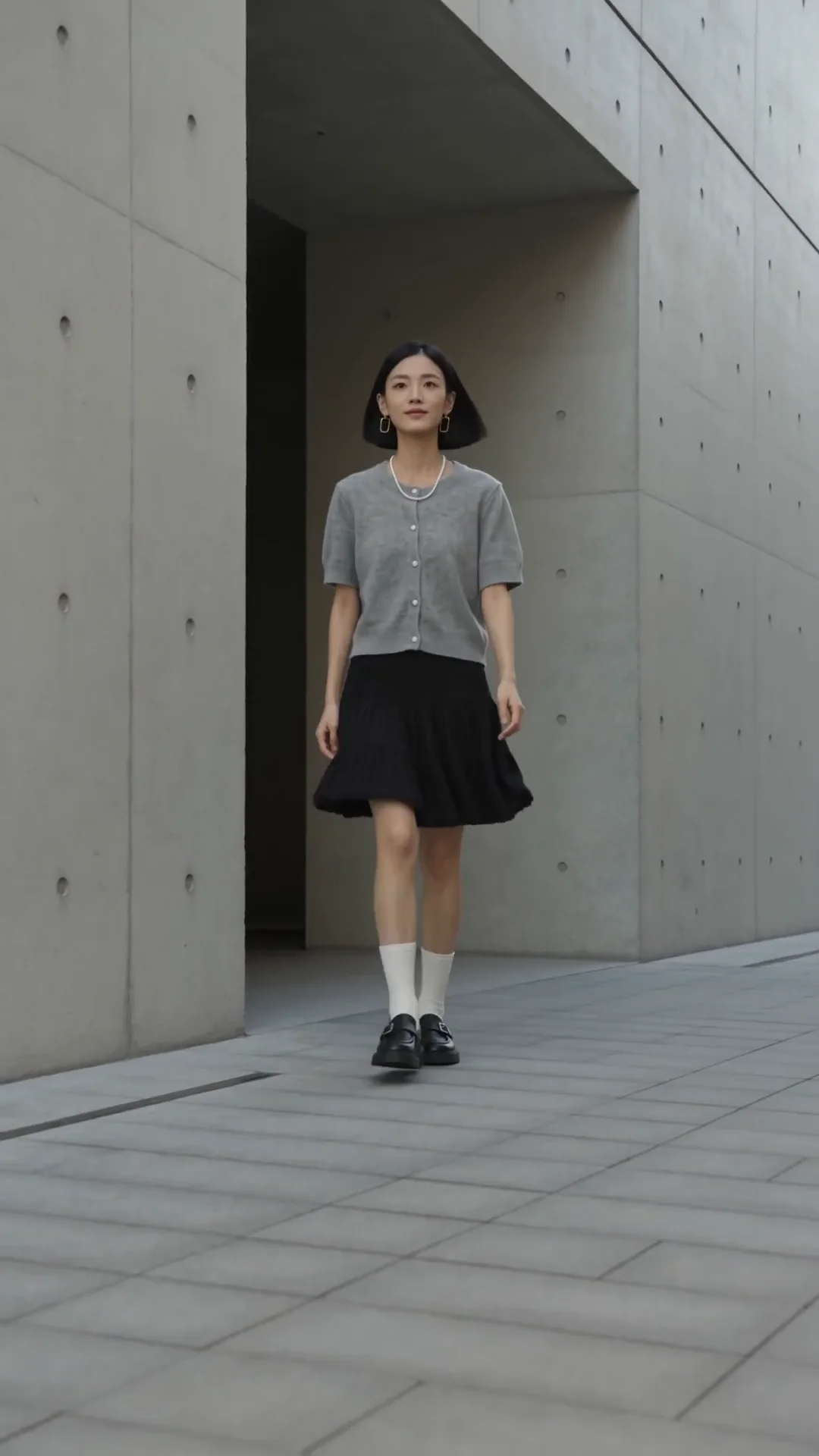 灰色针织服装在明亮空间中随人物动作呈现柔软质感